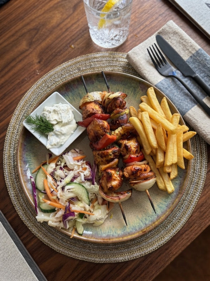 Chicken skewers with fries and salad